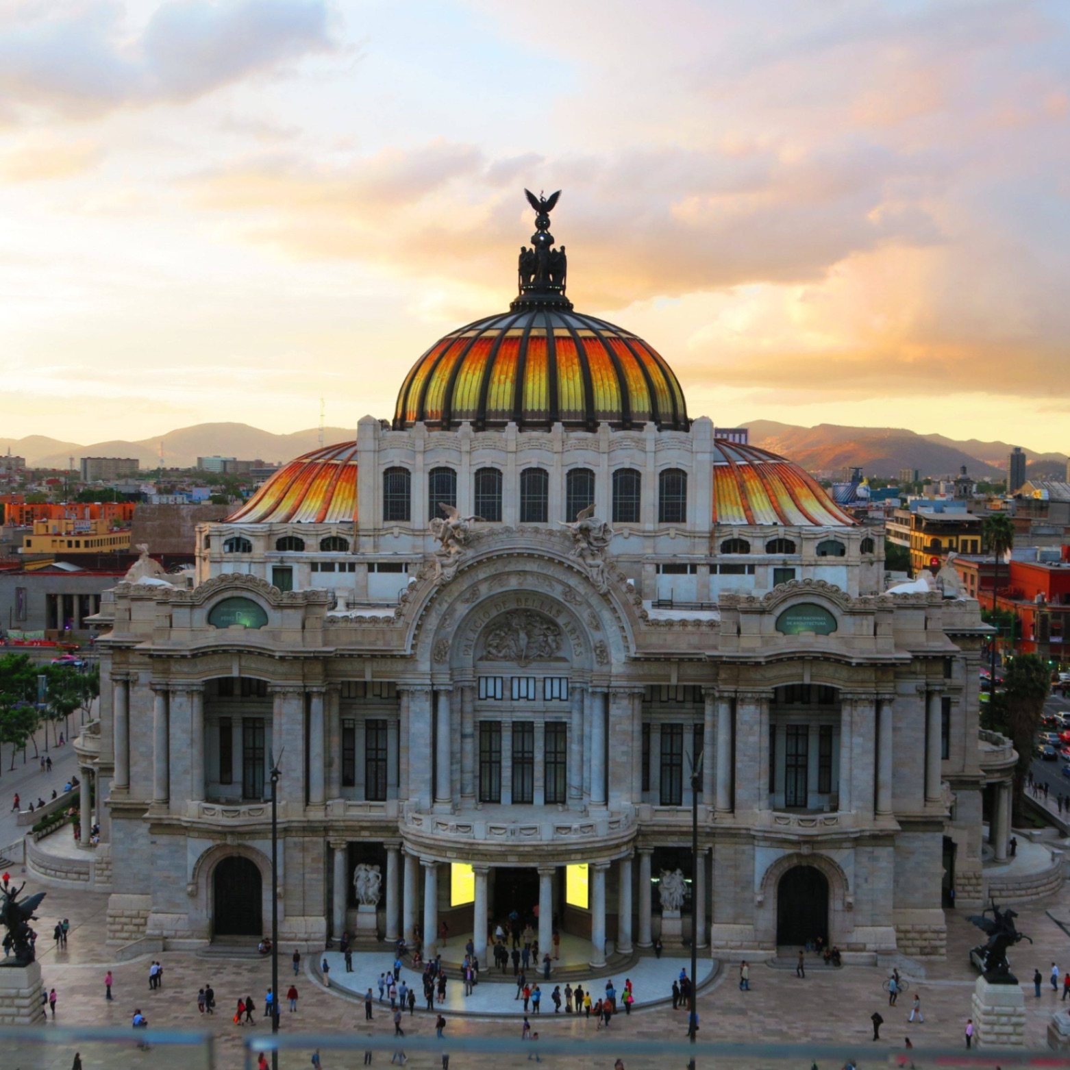 The Palacio de Bellas Artes with its golden dome beneath a sunset sky in Mexico City